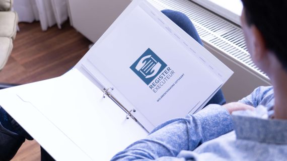 Man bekijkt een map van de Register Executeur met documenten over wilsbeschikking en nalatenschapsbeheer.